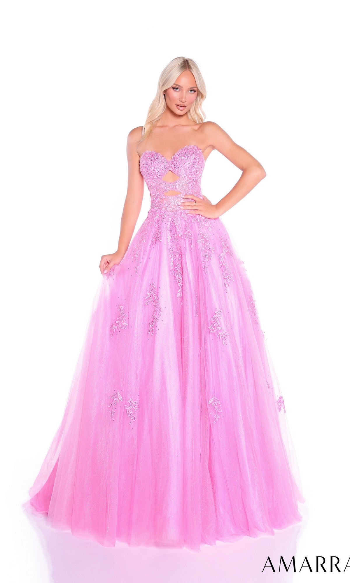A woman poses against a white background in the Amarra 89357, a strapless bright pink long prom dress featuring an A-line silhouette, floral appliqué details, and a sheer bodice cut-out.